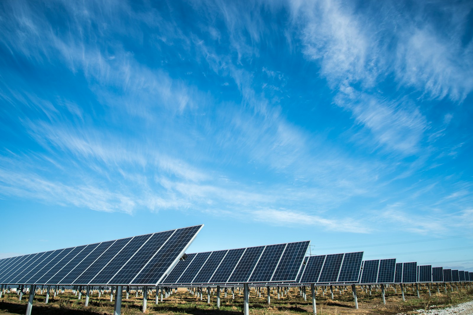 Photovoltaic modules under a clear sky, suggesting solar-plus-storage plants.